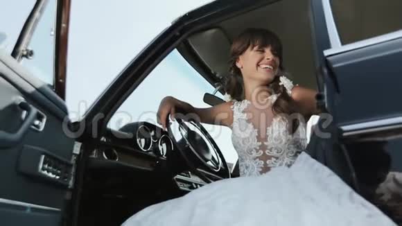年轻美丽的女人穿着婚纱穿着老式汽车视频的预览图