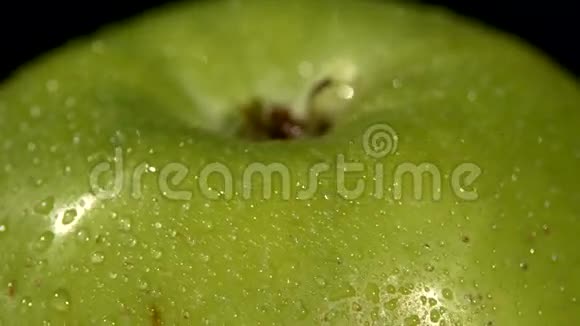 在黑色上分离的湿绿苹果顶部旋转视频的预览图