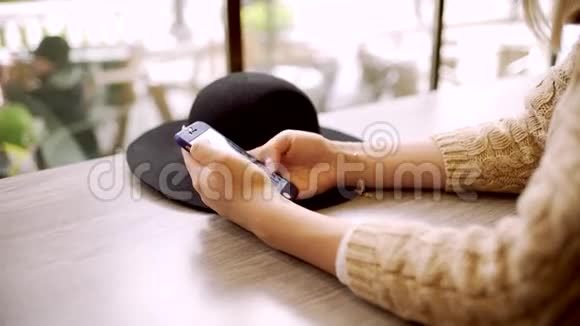 关闭年轻女子手在咖啡馆打电话的信息视频的预览图