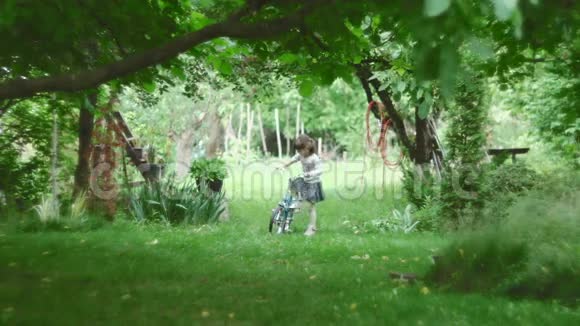 可爱的女孩在大自然中骑自行车视频的预览图