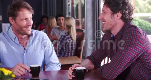 两个成熟的男性朋友坐在咖啡店聊天视频的预览图