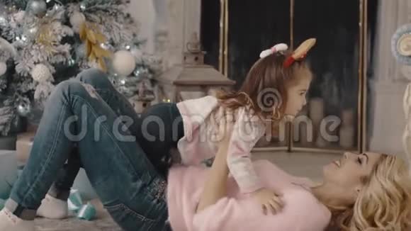 年轻的母亲和女儿在圣诞树附近玩耍视频的预览图