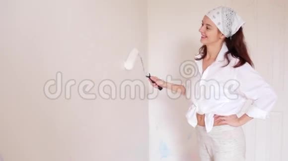 这位年轻女子正在把房间漆成白色微笑着视频的预览图