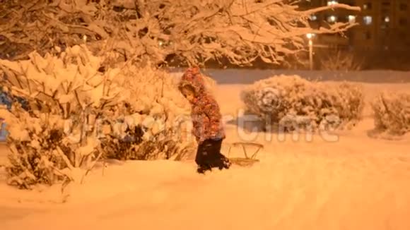 儿童雪中雪橇儿童游戏冬季公园雪橇夜光视频的预览图