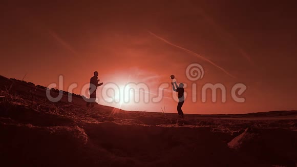 排球两名男子在日落阳光下打排球剪影在海滩上运动视频的预览图