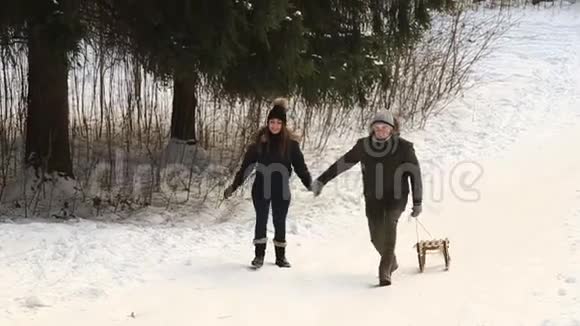 男孩和女孩雪橇冬天下雪的天气家庭幸福圣诞节的心情视频的预览图