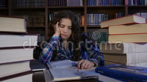 一个疲惫的学生正在图书馆准备考试4K视频的预览图