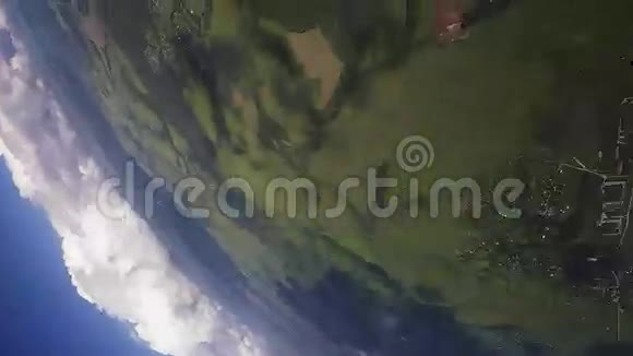 跳伞员在空中打开降落伞飞在绿色的田野上高度极限运动视频的预览图