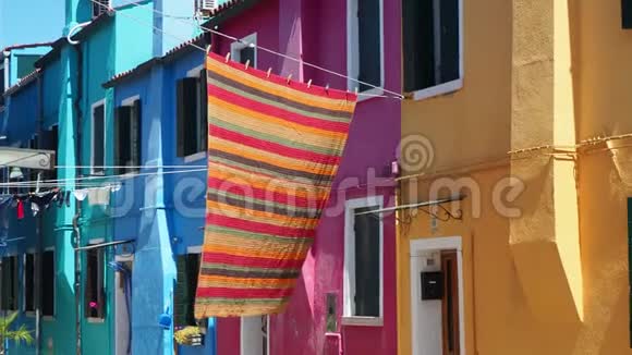 意大利威尼斯的布鲁诺街上有五颜六色的房子和彩色桌布摊开晾干视频的预览图