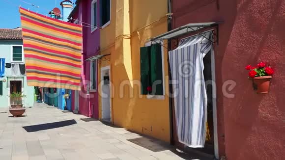 意大利威尼斯的布鲁诺街上有五颜六色的房子和彩色桌布摊开晾干视频的预览图