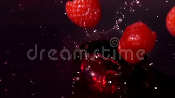 成熟的红树莓落入果汁中视频的预览图