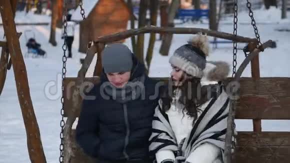 冬季公园的浪漫情侣在荡秋千视频的预览图