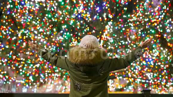 纽约洛克菲勒圣诞树背景下的快乐女孩洛克菲勒美丽的圣诞树视频的预览图