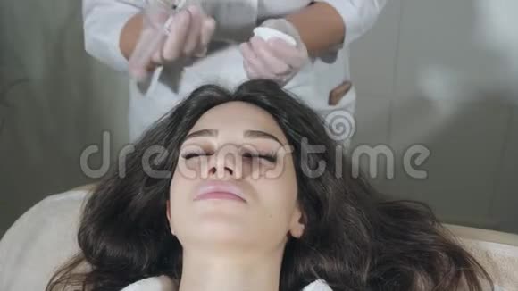 英俊的女人头部受到注射这个程序使医生戴着白手套中间疗法的概念视频的预览图