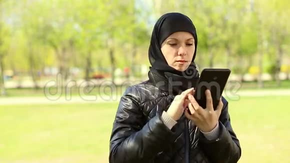 穆斯林妇女手里拿着平板电脑在户外全高清视频视频的预览图