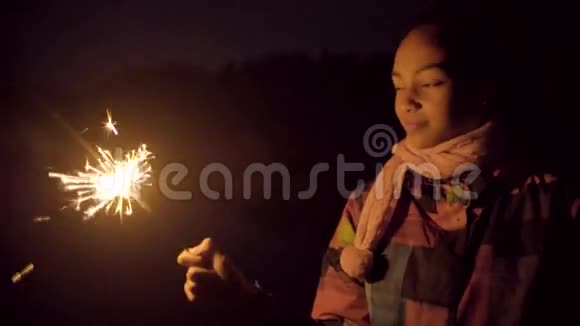 快乐的黑人女孩用火花在空中画线条视频的预览图