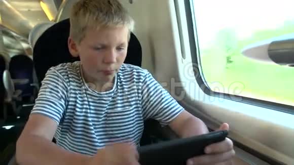 男孩阅读E书火车之旅视频的预览图