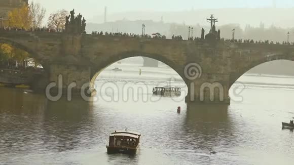 查尔斯桥查尔斯桥上的游客布拉格日落时一艘旅游船的背景视频的预览图