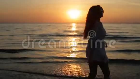 日落海滩上的女子剪影翩翩起舞视频的预览图