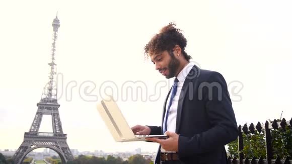 旅行经理使用笔记本电脑与埃菲尔铁塔背景慢动作视频的预览图