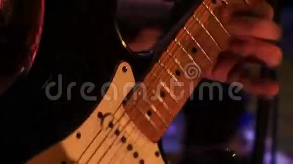 近距离吉他手触电吉他弦在夜间酒吧视频的预览图