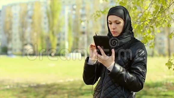 穆斯林妇女手里拿着平板电脑在户外全高清视频视频的预览图