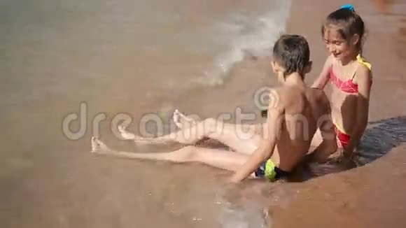 孩子们男孩和女孩在海滩上玩沙子视频的预览图