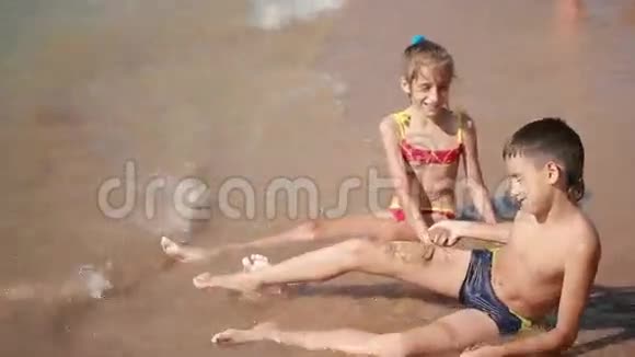 孩子们男孩和女孩在海滩上玩沙子视频的预览图