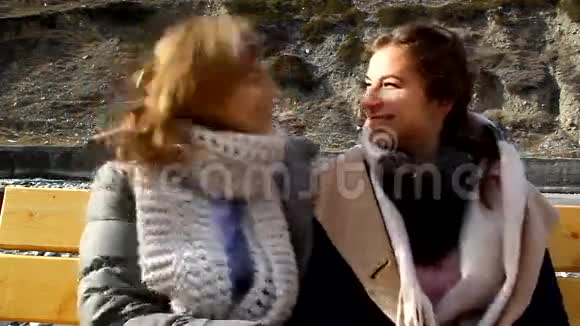 母女俩坐在公园的长椅上拥抱亲吻视频的预览图
