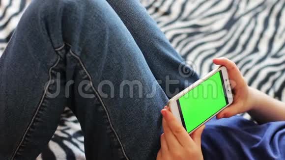 手持触摸屏设备用智能手机特写男孩的手彩色钥匙绿色屏幕视频的预览图