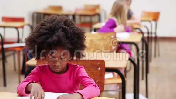 小学生坐在桌子旁视频的预览图