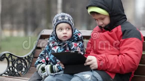 可爱的小男孩看着他哥哥视频的预览图