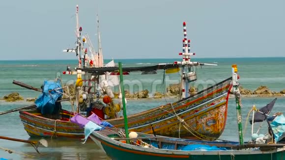 热带海洋沙滩停泊木制传统多彩渔船亚洲贫困穆斯林渔夫村附近的海景视频的预览图