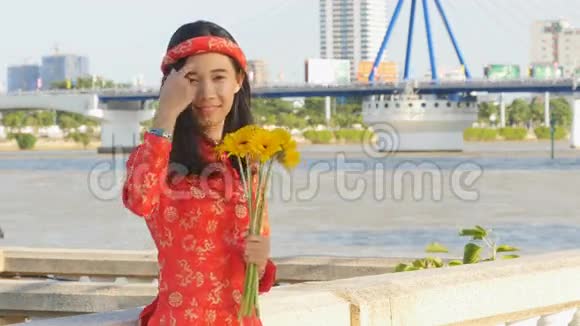 美丽的越南女孩穿着红色的传统服装戴着黄色的花视频的预览图