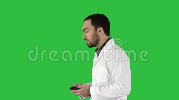 医生用手机在绿色屏幕上说话Chroma键视频的预览图