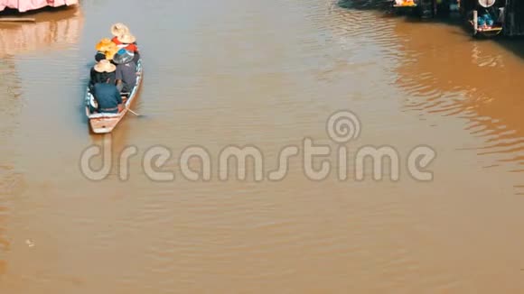 人们在一条棕色的河上乘船去泰国在河上乘船四方水上市场视频的预览图