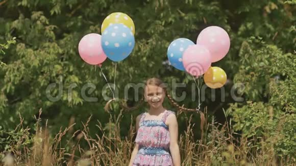 开朗漂亮的女孩她的头发上有五颜六色的球头上有辫子气球真有趣视频的预览图
