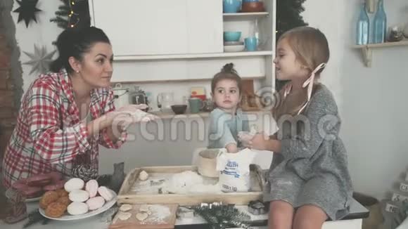 厨房里的幸福家庭妈妈和孩子们准备面团烤饼干视频的预览图