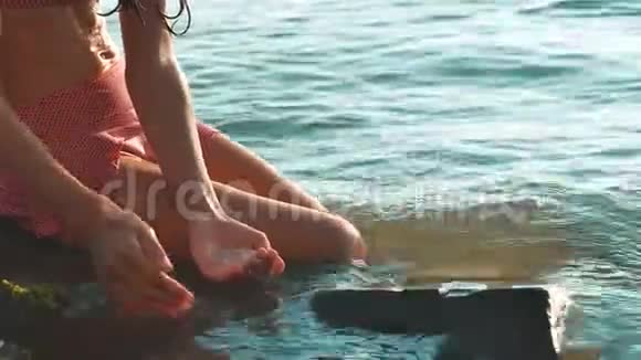 小女孩在海里沐浴岩石和石头的生活方式少女的女儿在水中畅游视频的预览图