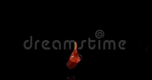 一杯番茄汁在黑色背景上跳跃和飞溅慢动作视频的预览图
