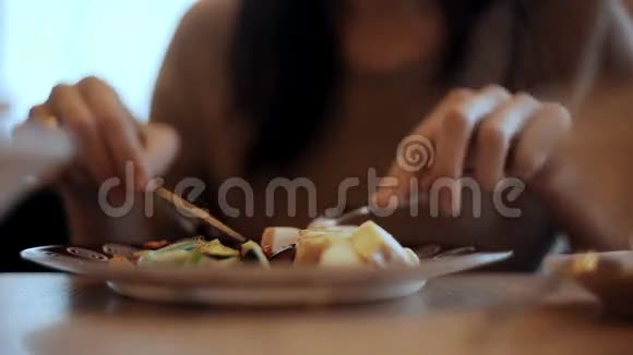 女人在咖啡馆里吃蔬菜和肉视频的预览图