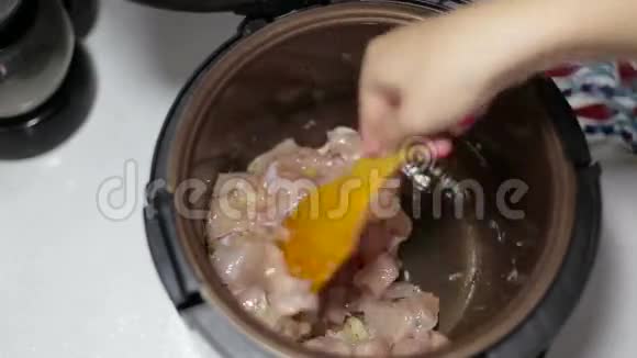 女性用手将食物放入锅中视频的预览图