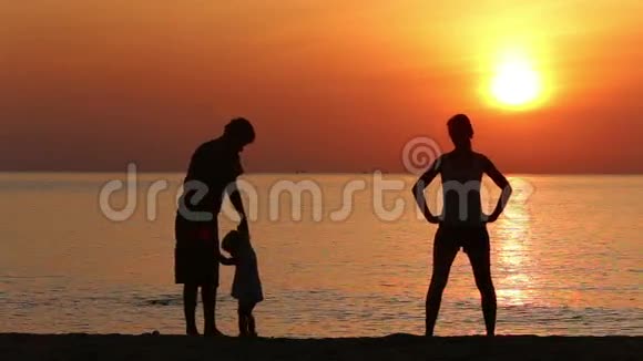 一家人在海上日出时做运动的剪影视频的预览图