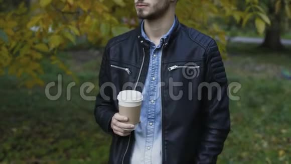 帅哥模特在秋季公园喝咖啡视频的预览图