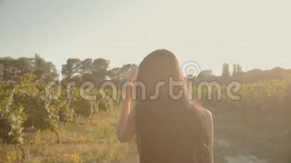 在葡萄园里穿着轻盈飘逸的裙子的女孩视频的预览图
