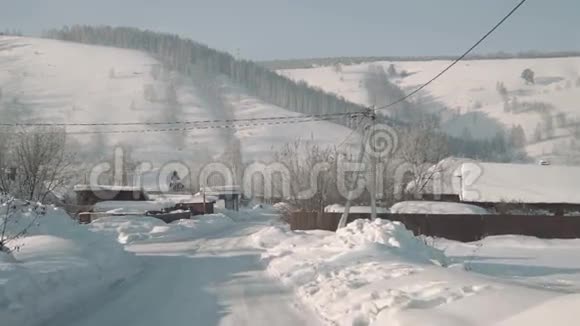 冬天美丽的山村传统的房屋和汽车道路被大雪覆盖视频的预览图