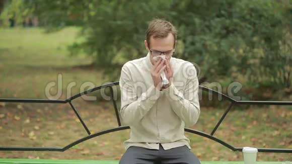 年轻人拿着手帕在鼻子上一个人得了重感冒视频的预览图