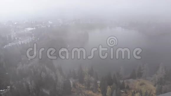 斯洛伐克StrbskePleso的空中景观云雾中的山湖和雪山视频的预览图