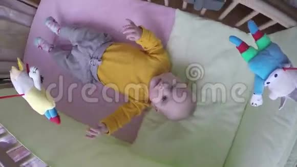 有兴趣的宝宝看旋转木马玩具旋转在床上4K视频的预览图