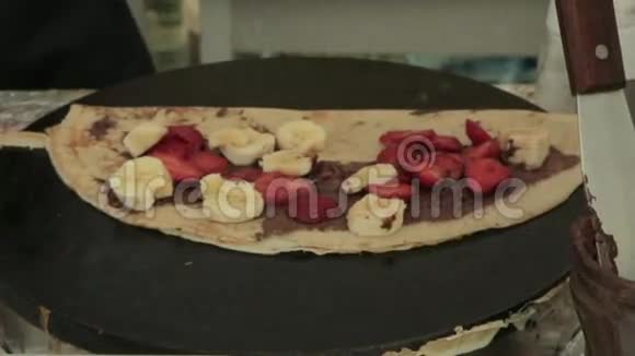 带水果和巧克力糖浆的新鲜煎饼视频的预览图